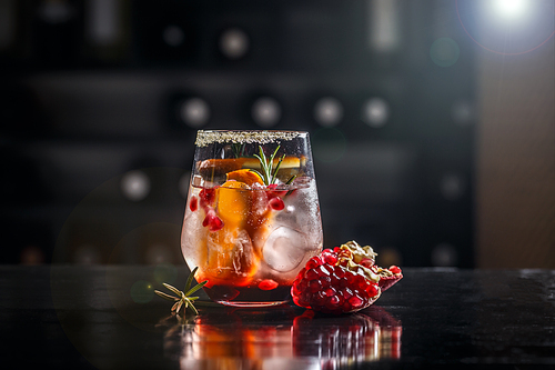 Pomegranate and orange cocktail with tonic water in glass