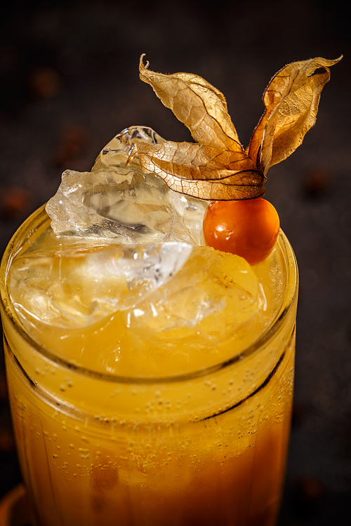 Close up of iced orange juice decorated with cape gooseberry