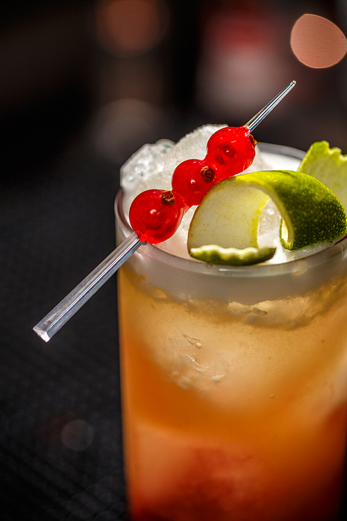 Close up of tasty alcoholic cocktail with lime peel garnish