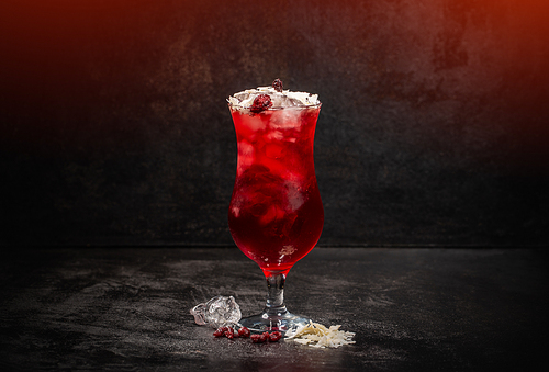 Cold summer berry syrup drink with coconut shavings and ice cubes