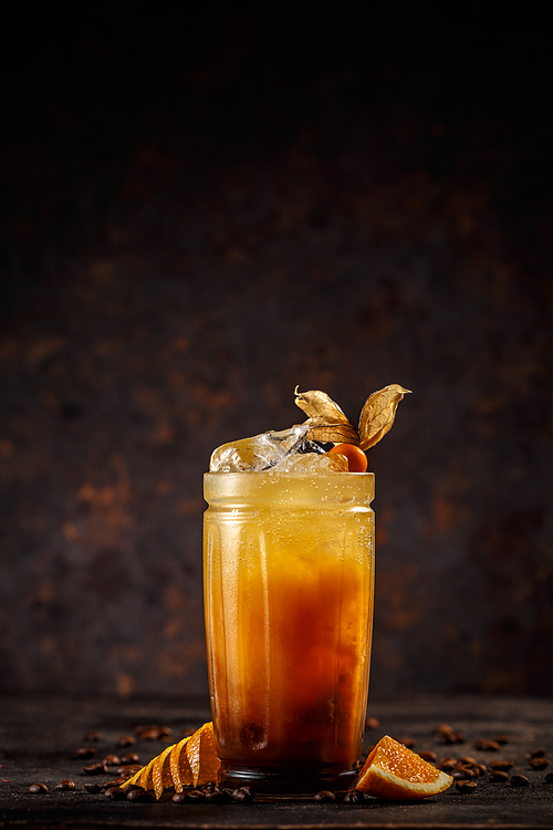 Orange and coffee cocktail with ice decorated with cape gooseberry