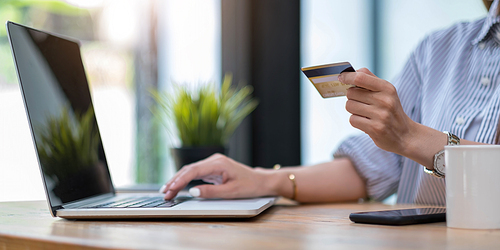 Online payment,Young woman's hands using computer and hand holding credit card for online shopping