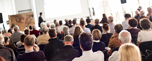 Speaker Giving a Talk at Business Meeting. Audience in the conference hall. Business and Entrepreneurship. Panoramic composition suitable for banners.