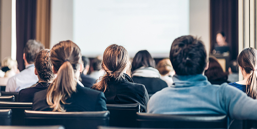 Speaker Giving a Talk at Business Meeting. Audience in the conference hall. Business and Entrepreneurship. Panoramic composition suitable for banners.