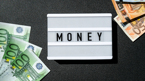 Lightbox board with the word MONEY in black letters around Euro banknotes. Finance background. Business, financial success and making money concept. Business budget of wealth and prosperity finance. Euros Cash Bill