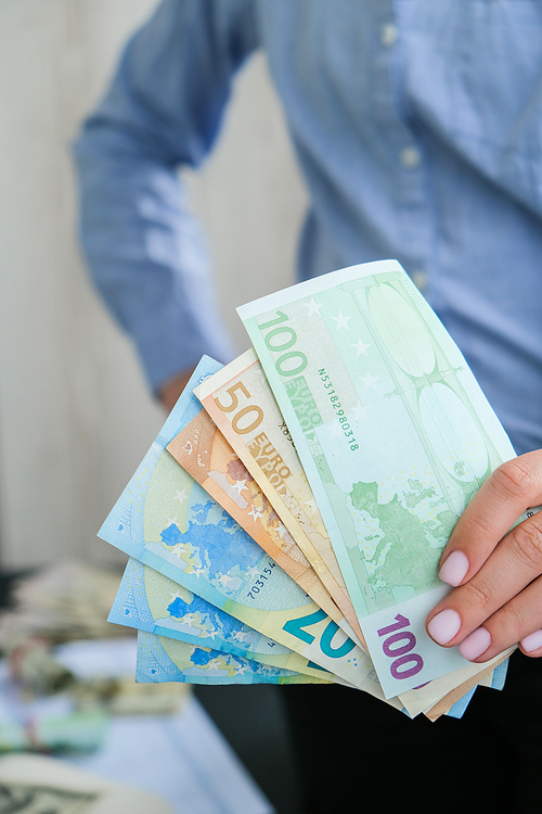 Business Woman Displaying a Spread of Cash euros. Close-up. Income and Business concept. Venality, bribe, corruption concept. Hand giving money. Millennial candid authentic female hands counting money. Business budget of wealth and prosperity finance