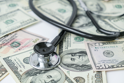 Stack of cash dollars and stethoscope. The concept of medical expensive medicine, doctors salary. Copy space for text. Health Life insurance. vaccination costs. Financial crisis. Covid-19 crimes