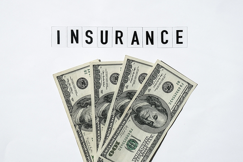 Text INSURANCE around US dollar banknotes. Health, life, home, car Insurance. Insurance business concept. Business budget of wealth and prosperity finance. Health care or medicare insurance and vaccination costs. Financial crisis. Covid-19 crimes