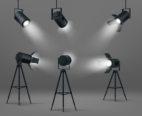 Spotlights for studio or stage. Vector realistic set of glowing floodlights for illumination show, concert or podium. Black spot lamps on stand and hanging on gray background