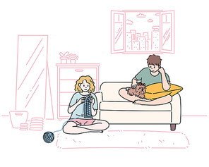 남녀가 거실에 편안하게 앉아있다. 남자는 개를 보고 있고 여자는 뜨게질을 하고 있다.