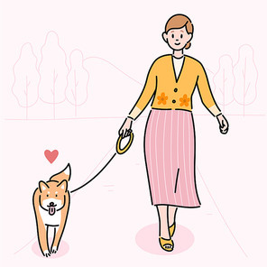 한 여성이 개와함께 산책을 하고 있다.