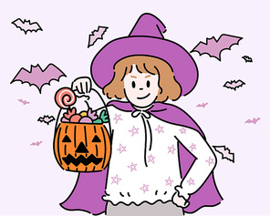 할로윈 마녀 의상을 입은 꼬마가 사탕이든 호박 바구니를 들고 있다.