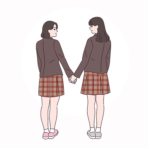 두 여학생이 손을 잡고 서로를 바라보고 있다