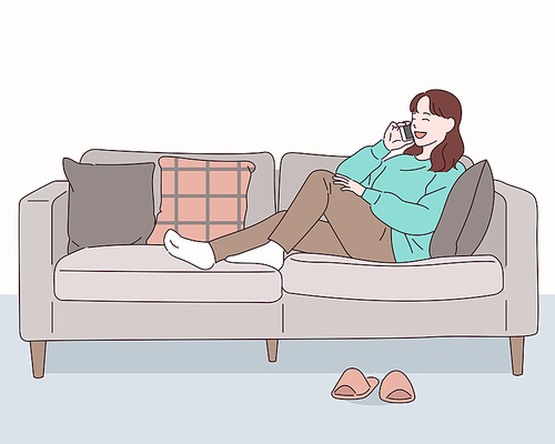 소파에 편안하게 앉은 소녀가 전화통화를 하고 있다.