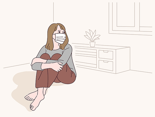 한 여성이 마스크를 쓰고 집에 자가격리를 하고 있다.