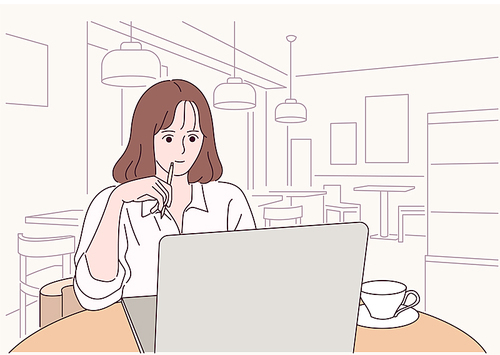 한 여성이 카페에서 노트북을 보며 공부를 하고 있다.