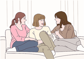 세 소녀가 소파에 앉아 수다를 떨고 있다.