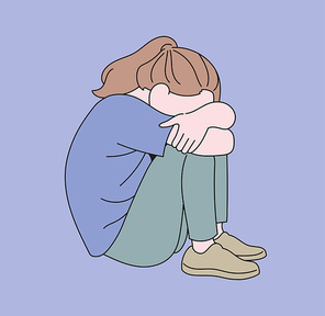 한 소녀가 무릎에 얼굴을 파묻고 앉아있다.