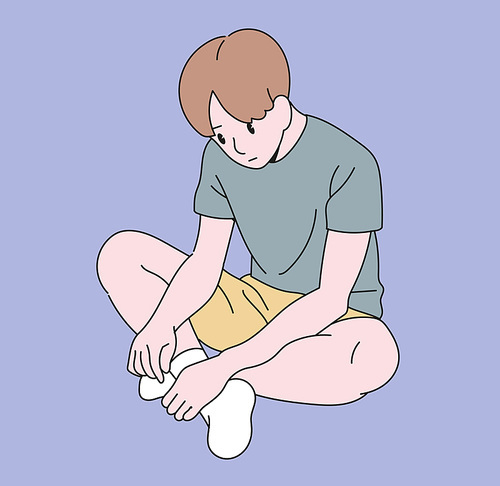 한 소년이 심각한 표정으로 앉아서 바닥을 보고 있다.