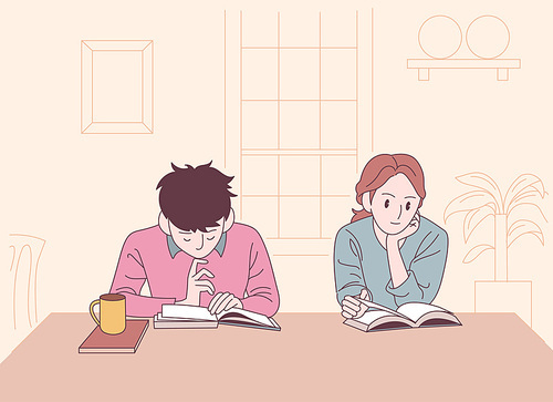 두사람이 카페 테이블에 앉아 책을 읽고 있다.