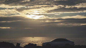 해질녘, 자동차와 바다위에 떠있는 고깃배의 실루엣 풍경