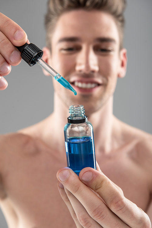 Close Up Portrait Of Joyful Naked Guy Holding Glass Dropper And