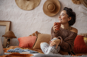 Happy woman enjoying with hot drink in room stock photo