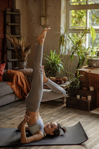 Happy and beautiful woman doing exercise of yoga at home