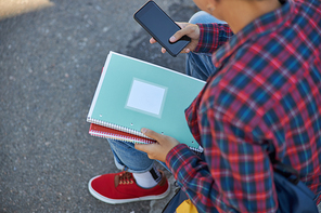 Male student sitting with mobile phone stock photo