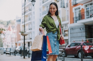 Happy Asian lady holding shopping bags stock photo