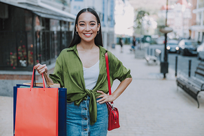 Smiling pretty lady holding bags outdoors stock photo