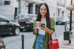 Smiling pretty woman with smartphone in the city stock photo