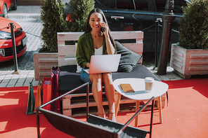 Happy woman with laptop in cafe outdoors stock photo
