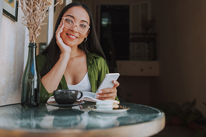 Smiling young woman sitting in cafe stock photo