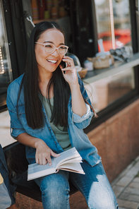 Happy pretty woman talking on smartphone in the city stock photo
