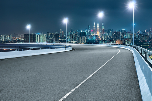 High speed corner overpass asphalt road with modern cityscape , night scene .