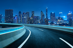Blue neon light highway overpass motion blur with city  skyline background , night scene .