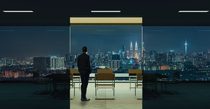 Businessman standing in office watching city night view . Business ambition and vision concept .