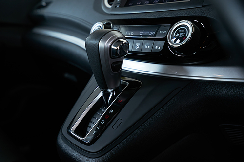 Close up automatic gear stick inside modern luxury car interior .