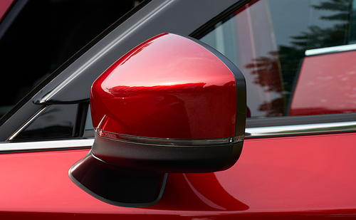 Close up of the side mirror of a red car