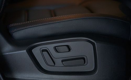 Closeup of a modern car interior with adjustable front seat button
