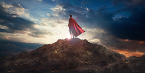 Businessman in a suit and cape hero on top of a mountain,Business Success concept.