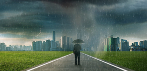 Businessman below storm rain with umbrella , risk and crisis concept .