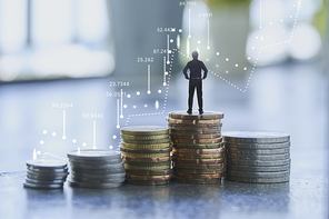 Businessman standing on coins stack with graph chart. Economic, business, financial and stock market growth concept.