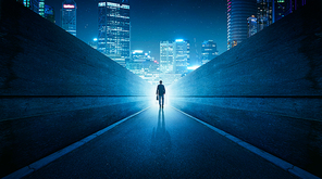 Ambitions concept with businessman walking from alley to modern city . Night scene .