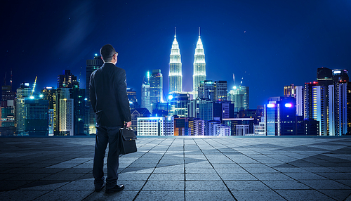 Rear view of a businessman looking at large city center. Concept of success and appreciation.