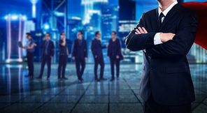 Closeup superhero leader and smart business team with night cityscape background .