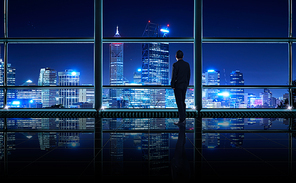 Back view of thoughtful businessman looking out of big office window at office ,planning future project concept,night scene .