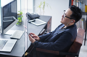 Young asian businessman listening music for relax