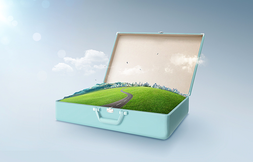 City skyline, green field, mountain and curvy asphalt highway in an open retro vintage suitcase isolated on light blue background .